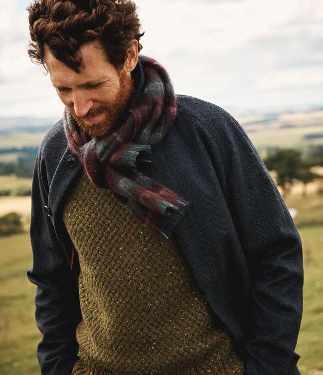 Man in thick green Aubin Jumper with navy jacket and red and blue scarf