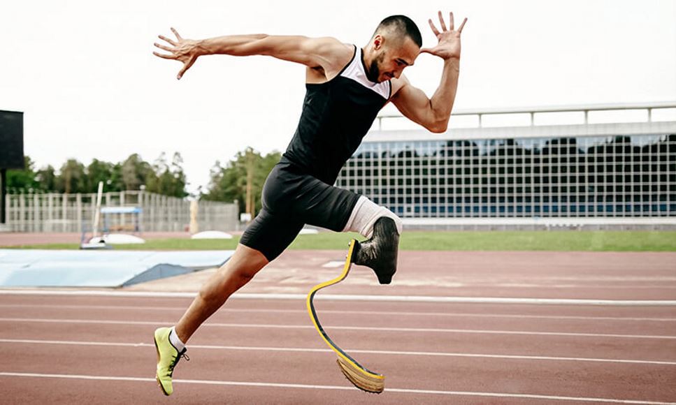 man with prosthetic leg sprinting on track
