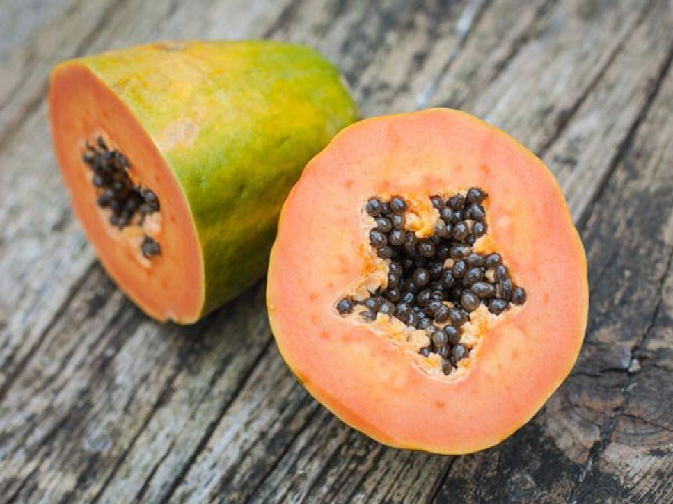 Papaya, one of many tropical fruits considered a "super fruit," sliced in half showing seeds.