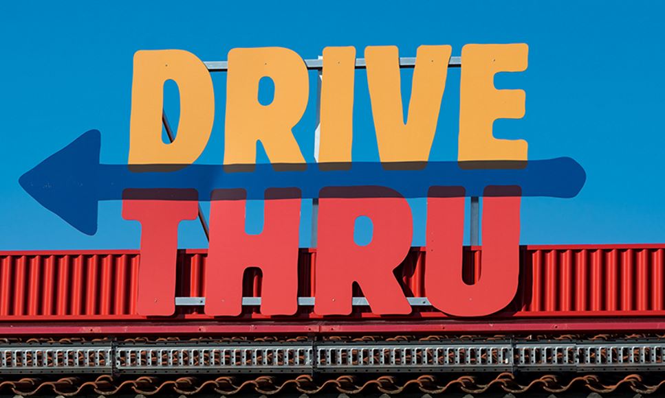 Drive thru sign lit up at a fast food or quick-service restaurant where meal options for kids have gotten healthier over the years.