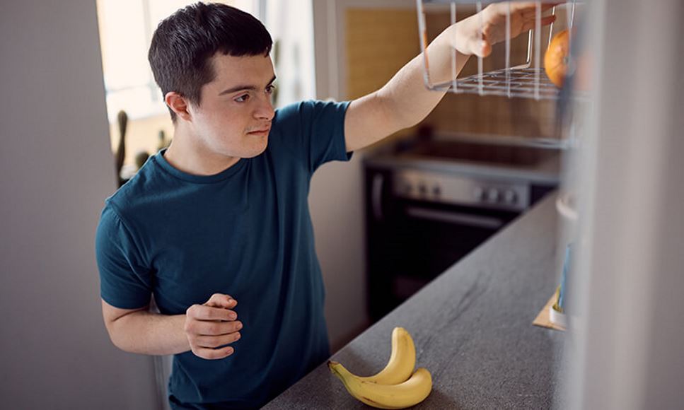 young man with intellectual disability reaching for fruit